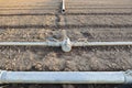 Irrigation metal pipes connections on recently seeded field Royalty Free Stock Photo