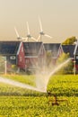 Irrigation sprinkler in front of Dutch houes with solar panels a Royalty Free Stock Photo