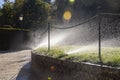 Irrigation system with several sprinklers spraying a rain of water on the green lawn of the garden Royalty Free Stock Photo