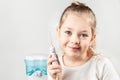 Irrigator. Pretty girl child holds electric water flosser in her hands and smiling