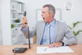 Irritated businessman answering phone Royalty Free Stock Photo