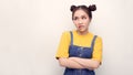 Irritated and dissatisfied girl with hairbun and oval face standing with arms akimbo, being displeased