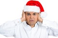 Irritated handsome man in red xmas hat shutting off his ears Royalty Free Stock Photo