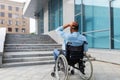 Irritated impaired black man in wheelchair having no possibility to enter building without ramp, outdoors Royalty Free Stock Photo