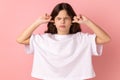 Irritated little girl in white T-shirt covering ears, keeping eyes closed, nervous breakdown. Royalty Free Stock Photo