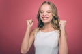 Irritated and mad young woman is getting crazy. She is upset. Girl has closed her eyes and holding her fists close to Royalty Free Stock Photo