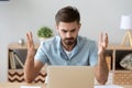 Irritated man looking at laptop screen sitting at the desk Royalty Free Stock Photo