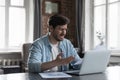 Irritated man staring at laptop feels concerned due awful news