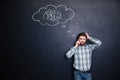 Irritated man using mobile phone standing over blackboard background Royalty Free Stock Photo