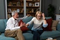 Irritated middle-age or senior couple has hard debate at home, sitting on the sofa and arguing, annoyed woman talking to angry man Royalty Free Stock Photo