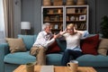 Irritated middle-age or senior couple has hard debate at home, sitting on the sofa and arguing, annoyed woman talking to angry man Royalty Free Stock Photo