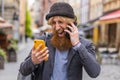 Irritated stressed business man talking on two mobile phones having conversation conflict quarrel