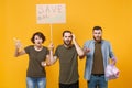 Irritated protesting young people hold protest broadsheet placard plastic bottles, trash bag isolated on yellow