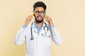 Irritated stressed doctor man talking on two mobile phones having conversation conflict quarrel