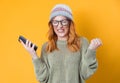 Irritated young woman talks on the phone, isolated on yellow background. Annoyed girl talking. Stressed person using smartphone Royalty Free Stock Photo