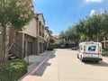 White USPS truck stops at apartment building complex on sunny da