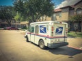 White USPS truck stops at apartment building complex on sunny da