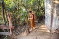 Isaan Region, Thailand - October 26, 2015: a Buddhist monk sweeps a temple in the middle of nature Royalty Free Stock Photo