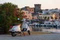 Ischia, Italy - July 20, 2017: Vintage white Vespa scooter parking in the port of Forio