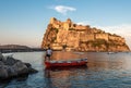 Ischia, Italy June 20, 2017: Boatman with a boat on the background of the Aragonese castle Royalty Free Stock Photo