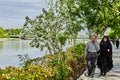 Iranian mature couple is walking along embankment of city river. Royalty Free Stock Photo