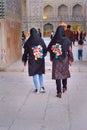 Two girls in hijab with the same pictures of portrait of girls in Isfahan. Iran