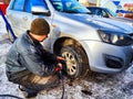 Ishim, Russia - November 27, 2023: A man makes tire of car wheel before cold snow season. Experienced mechanic changes