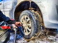 Ishim, Russia - November 27, 2023: A man makes tire of car wheel before cold snow season. Experienced mechanic changes