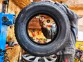 Ishim, Russia - November 27, 2023: A mechanic repairs a car wheel and makes a tire in a dirty garage. Replacement of