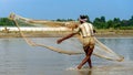 Ishwardi, Bangladesh - 10.10.2022: asian fisherman casts net into river. catching fish with net