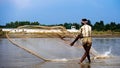 Ishwardi, Bangladesh - 10.10.2022: bengal fisherman casts net into river. catching fish with a net