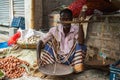 Ishwardi, Bangladesh - 10.10.2022: Old male vegetable seller with hand scales. An old Bangladeshi man sells vegetables on the Royalty Free Stock Photo