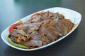 Iskender kebab with garnish on a wooden surface at restaurant