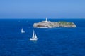 Isla de Mouro island in Santander, Cantabria, Spain. Sailing boat in the bay. Two sailboats and lighthouse