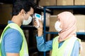 Islam Muslim asian warehouse worker taking temperature to worker