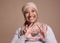 Islam woman, heart and sign with smile, happy and peace against brown studio background. Muslim lady, mature female and