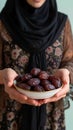 Islamic cuisine Woman holds plate of sweet dates for iftar