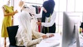 female merchandiser preparing clothing for customer at the office