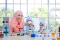 Islamic female teacher teaches science to two girls