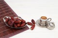 Islamic festival of Ramadan concept. With a delicious tropical dates on a silver plate and Turkish coffee on a white wooden table Royalty Free Stock Photo