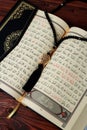 Islamic Holy Book Quran with rosary beads on wooden table background. Kuran the holy book os Muslims. Ramadan concept.