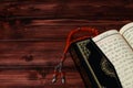 Islamic Holy Book Quran with rosary beads on wooden table background. Kuran the holy book os Muslims. Ramadan concept.