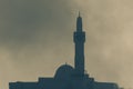 Islamic mosque in the hazy smoky hazy sky in combat and war. Conflict and religious war concepts