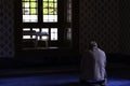 Islamic photo. Muslim man praying in the mosque in front of a window