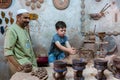 An Islamic potter teaching a boy making ceramic pots in Heritage villages in Abu Dhabi, United Arab Emirates