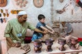 An Islamic potter teaching a boy making ceramic pots in Heritage villages in Abu Dhabi, United Arab Emirates