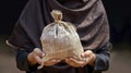 The Islamic Practice of Zakat Captured Through the Gesture of Hands Holding a Charity Money Bag Royalty Free Stock Photo