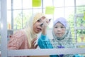 An Islamic teacher taught mathematics to a little girl in the classroom. Royalty Free Stock Photo