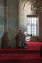 Islamic vertical photo. An elder muslim man praying in the mosque.