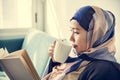 Islamic woman reading and drinking coffee Royalty Free Stock Photo